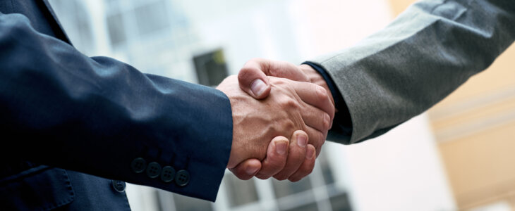 a business partnership forming with the business partner shaking hands