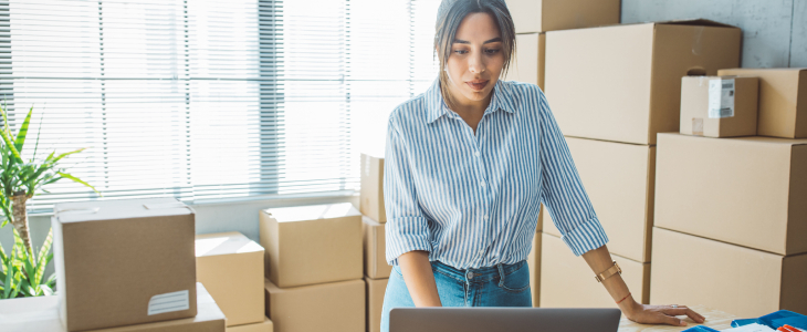 E-commerce business owner surrounded by shipping boxes