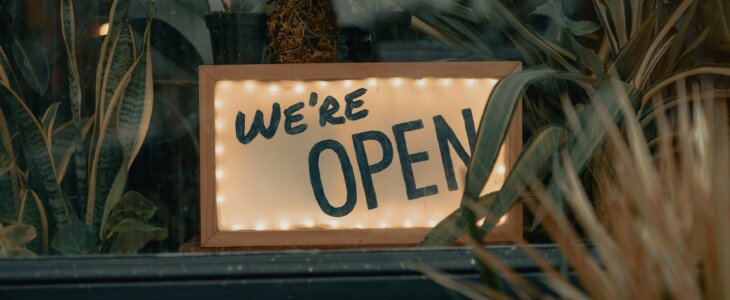 Sign saying 'We're Open' in a window.