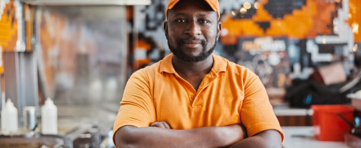 Franchise owner standing in restaurant with arms crossed