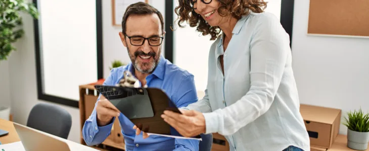 Two middle age business workers smiling happy working at the office.